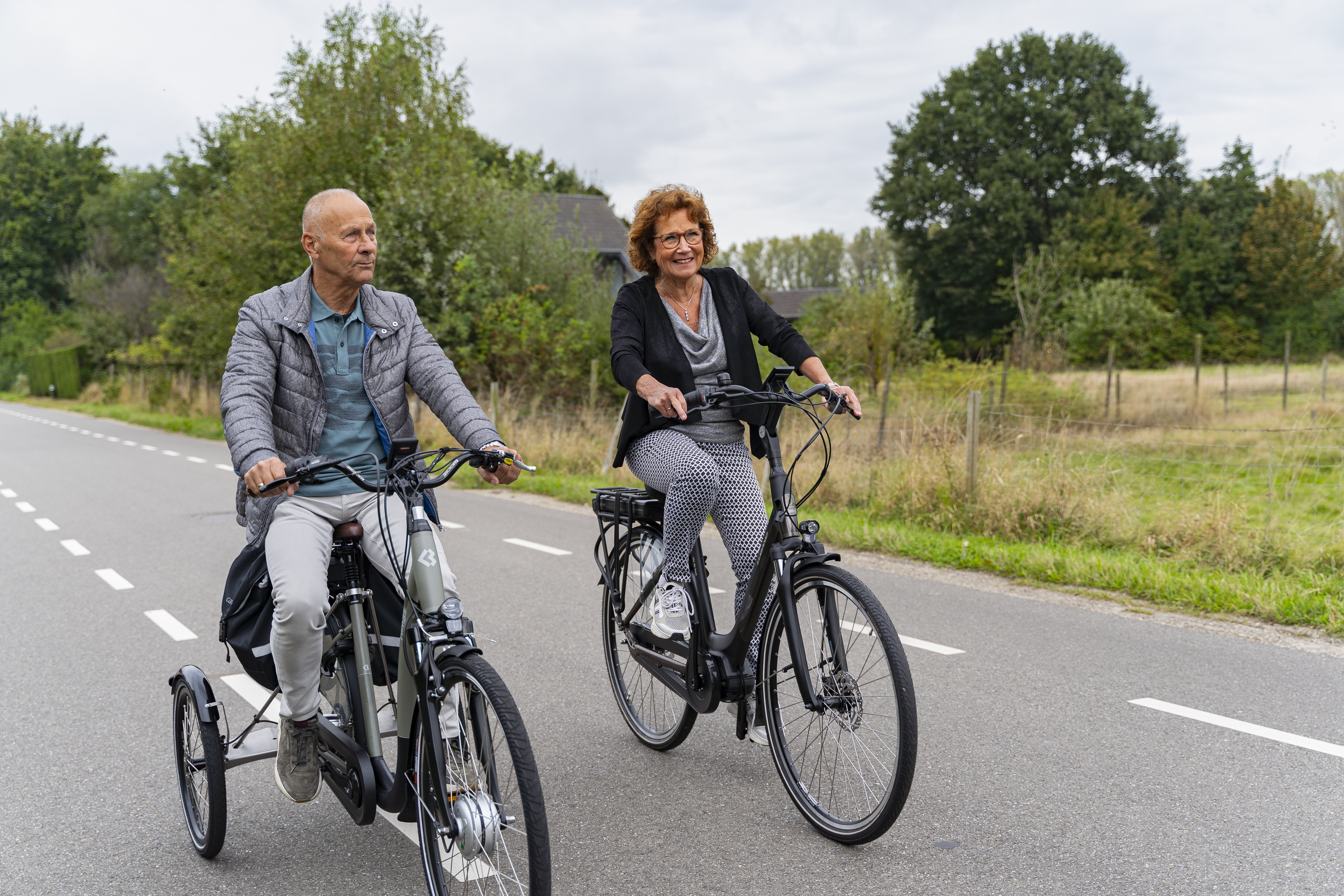 Senior test een Tworby tijdens een proefrit in de herfst, stabiel fietsen en veiligheid voor ouderen in het donker en bij slecht weer.